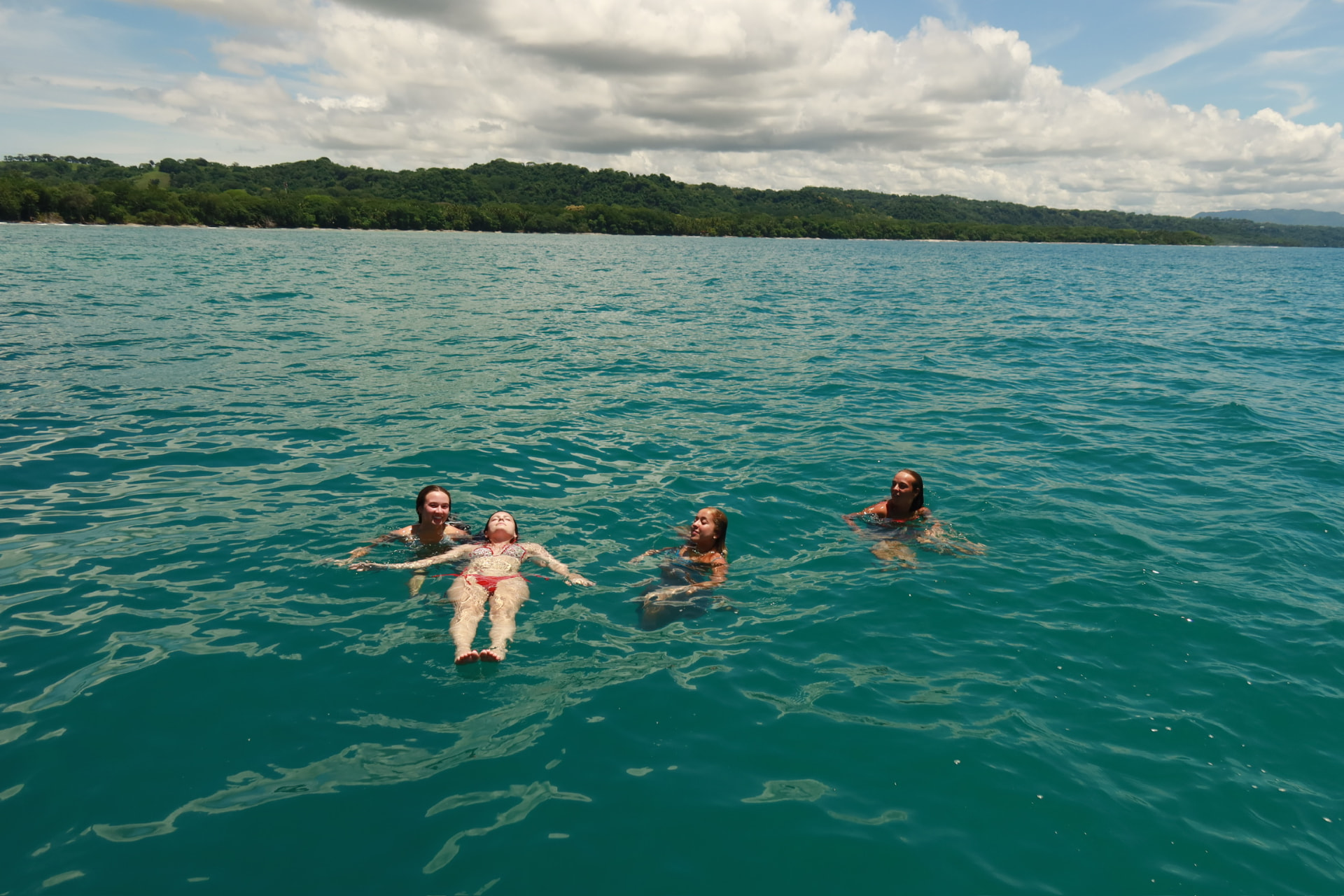 Guests floating on their backs in turquoise water on a boat day