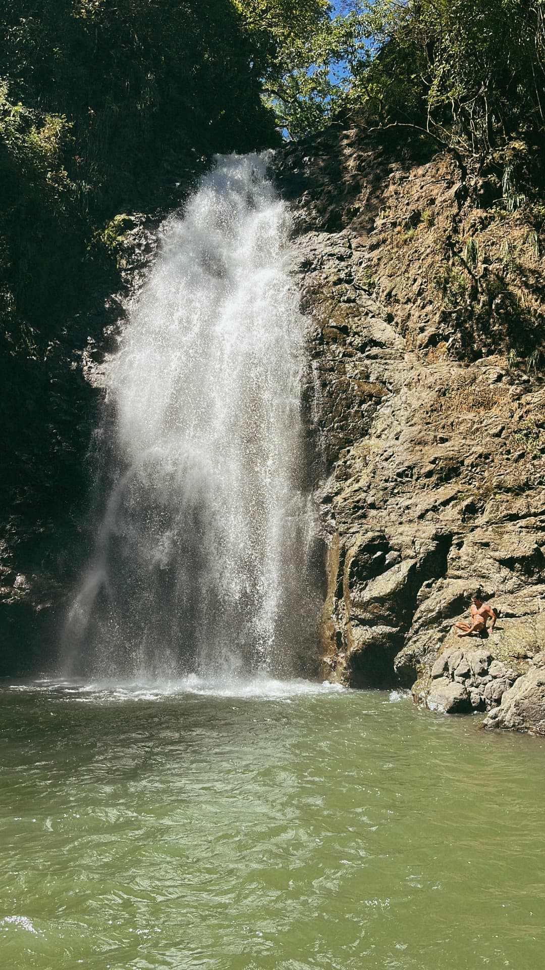 Montezuma waterfall crashing into a green swimming pool on a Beach Boys Cabo Blanco day trip