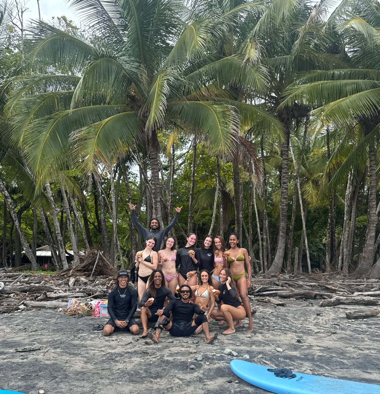 The whole crew posing with coconuts under the palms after a morning surf