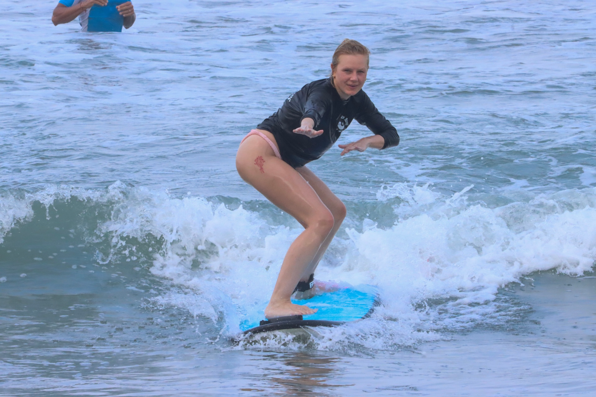 Surf coach guiding a beginner into a wave at Playa Santa Teresa